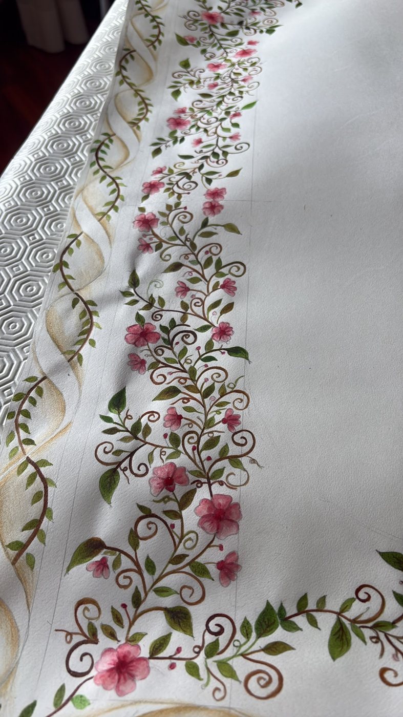 La decorazione laterale, osservata senza il testo al centro, lascia emergere la finezza dei tralci e l’alternanza fra piccoli fiori rosa e foglie affusolate.