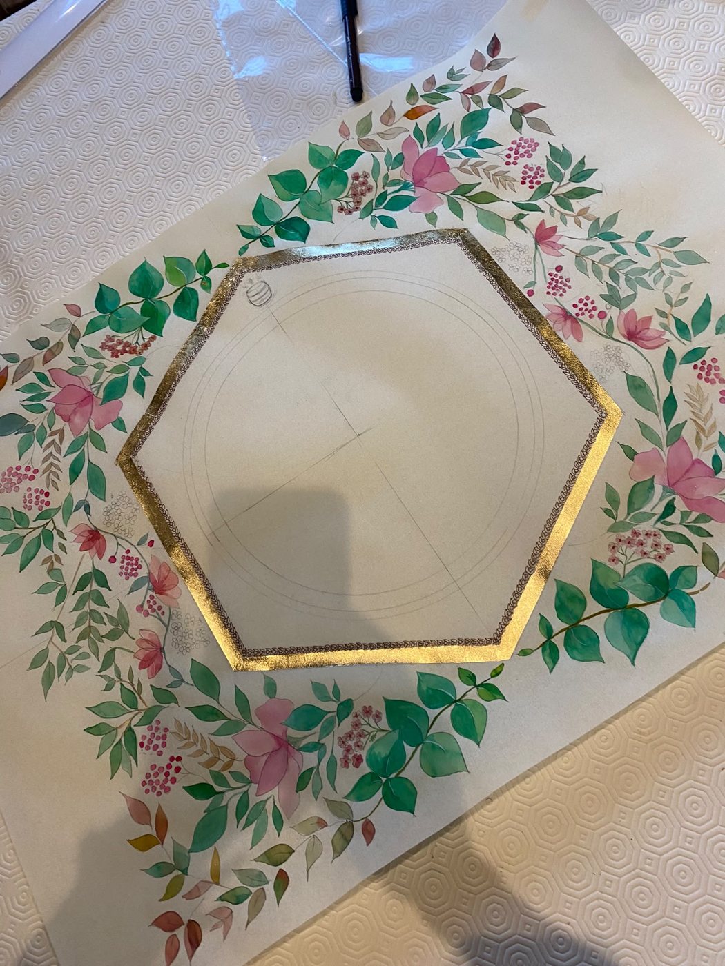 La decorazione completa rende evidente il contrasto fra il centro esagonale e la disposizione libera di foglie, petali e piccole bacche lungo i margini.