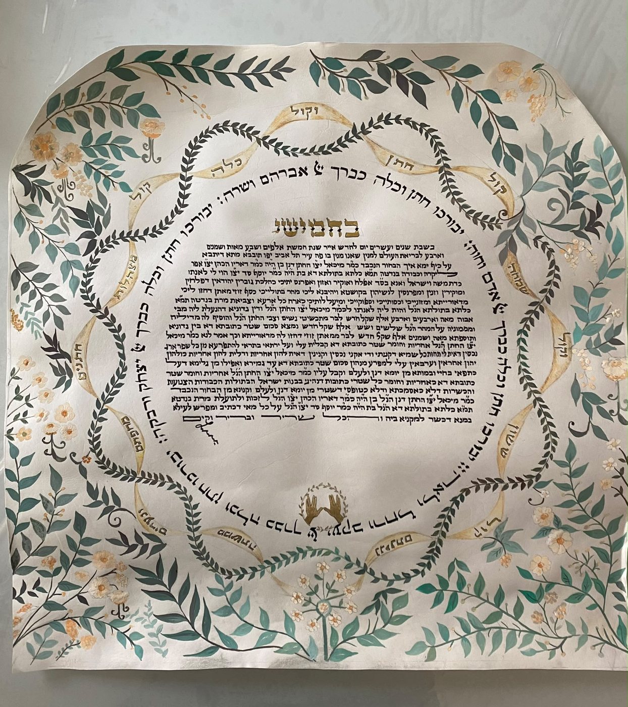 L’opera riunisce fogliame freddo, fiori chiari, cartigli dorati e ghirlande incrociate in una struttura concentrica, articolata attorno al blocco centrale della scrittura.